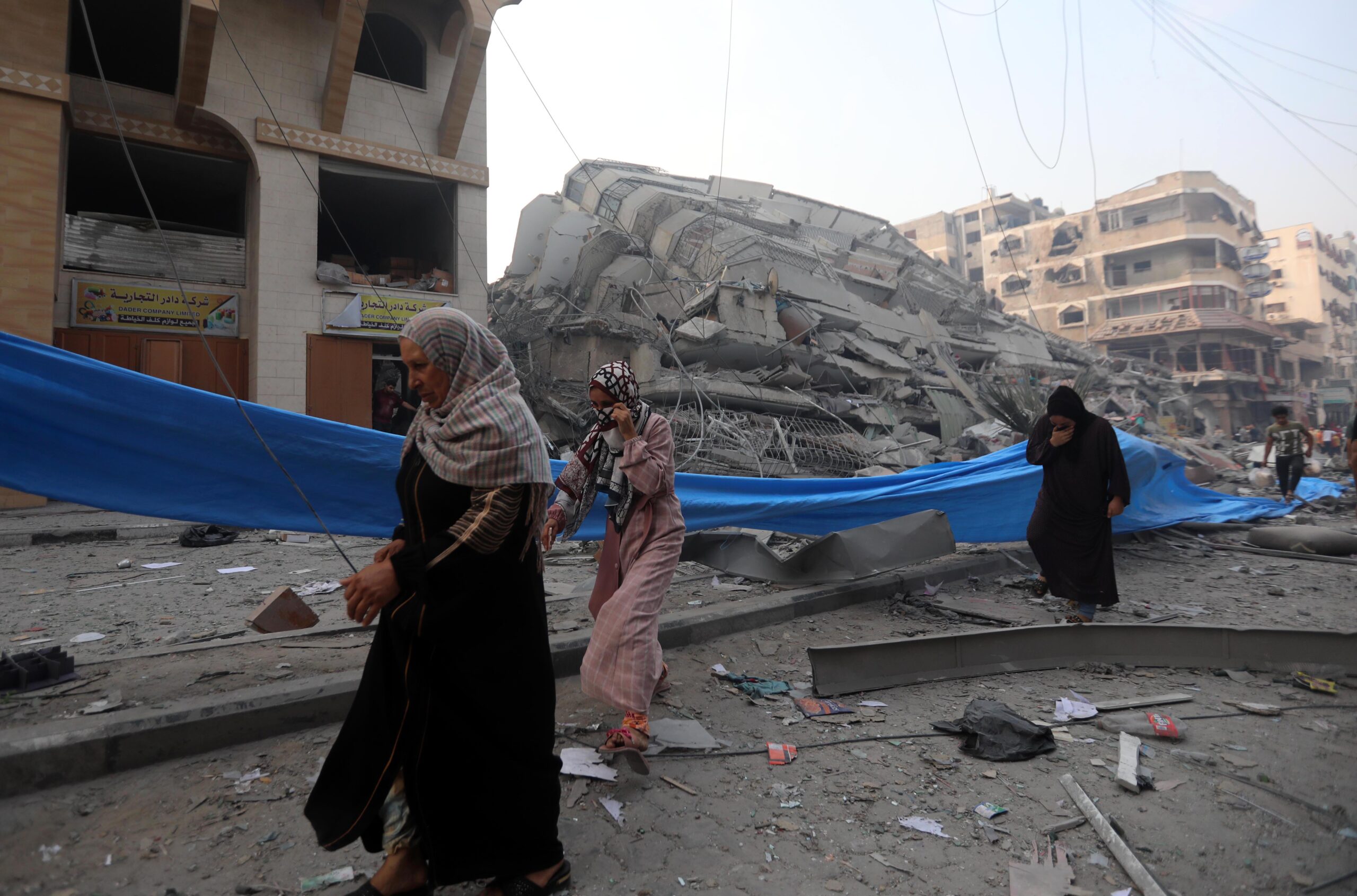 Three women walking through rubble after their house was destroyed in the Nasr neighbourhood in the Gaza Strip.