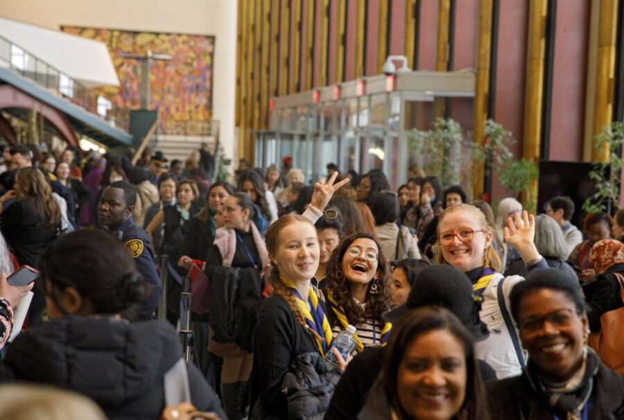 Women arrive at CSW67. They are smiling and waving to the camera.